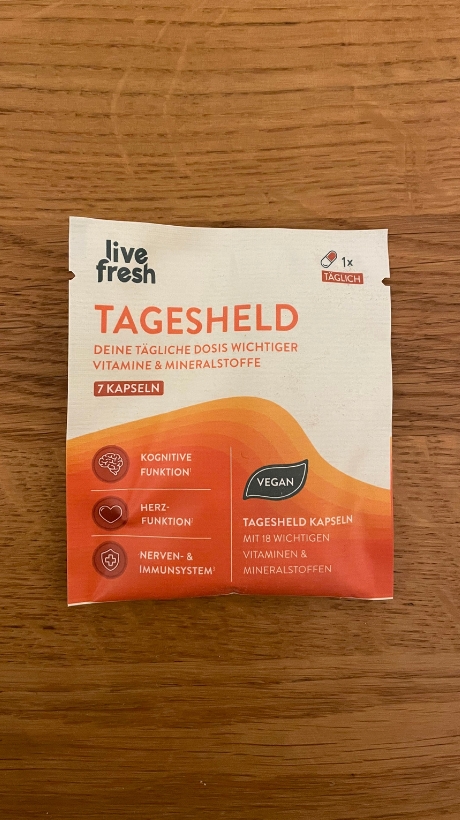 Eine Packung Livefresh Tagsheld Kapsel auf einem Holztisch.
